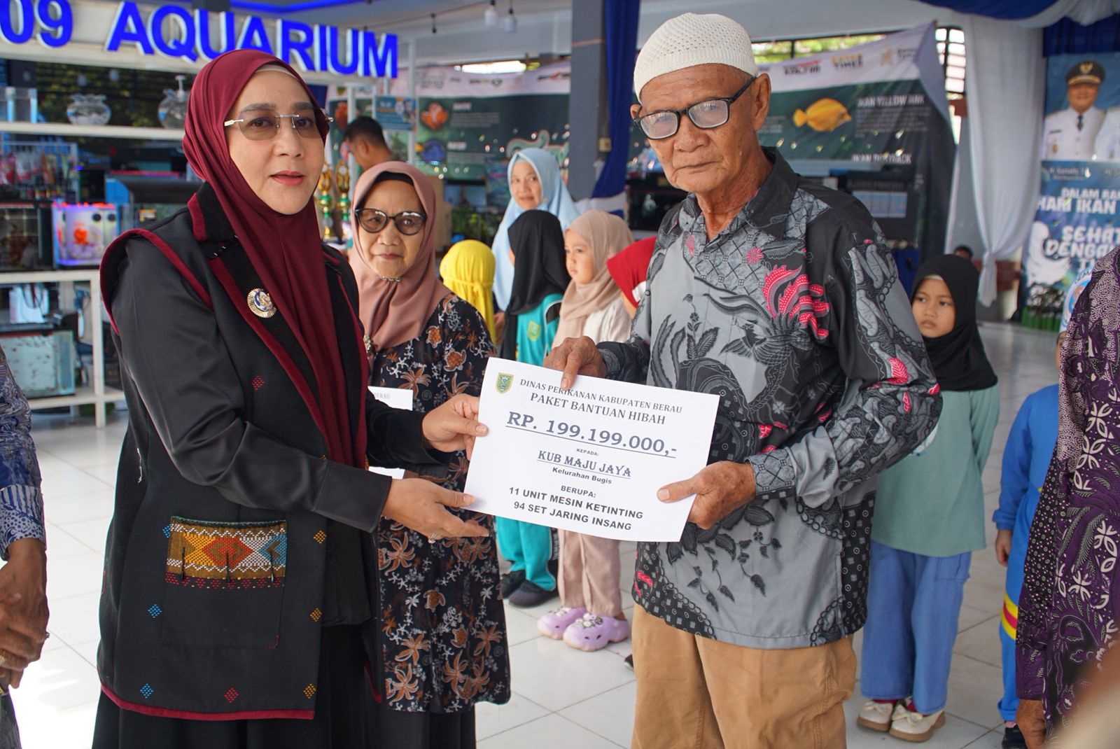 Bupati Berau, Sri Juniarsih, menyerahkan bantuan kepada KUB Maju Jaya Kelurahan Bugis saat penutupan peringatan Hari Ikan Nasional (Harkannas) ke-12 Tahun 2025 di halaman Gedung Graha Pemuda, Minggu (23/11/2025).