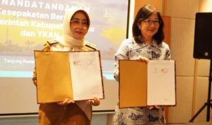Bupati Berau, Sri Juniarsih, dan Direktur Eksekutif YKAN, Herlina Hartanto, menunjukkan dokumen penandatanganan kerja sama di Hotel Mercure, Senin(13/10/2025). (Prokopim)